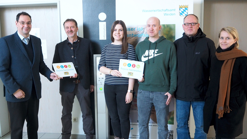 Gruppenbild: Übergabe des Signets „Bayern barrierefrei“ im Eingangsbereich des Wasserwirtschaftsamts Weiden.