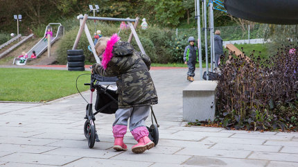 Lena ist mit ihrem Rollator im Freigelände der Kita unterwegs.