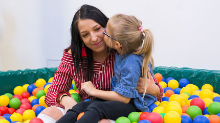 Nadine und Lena R. sitzen aneinander gekuschelt in einem Bällebad.