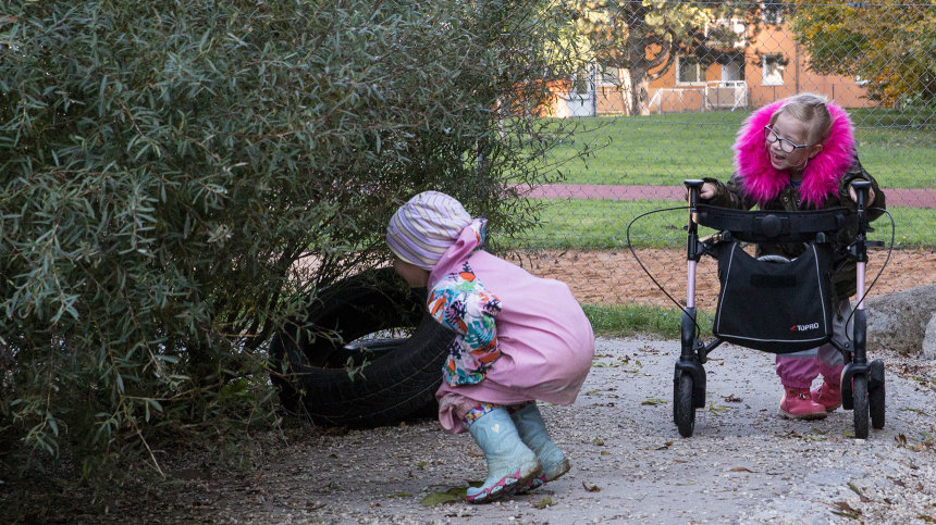 Versteckspiel: Lena und ein weiteres Mädchen suchen unter einem Gebüsch.