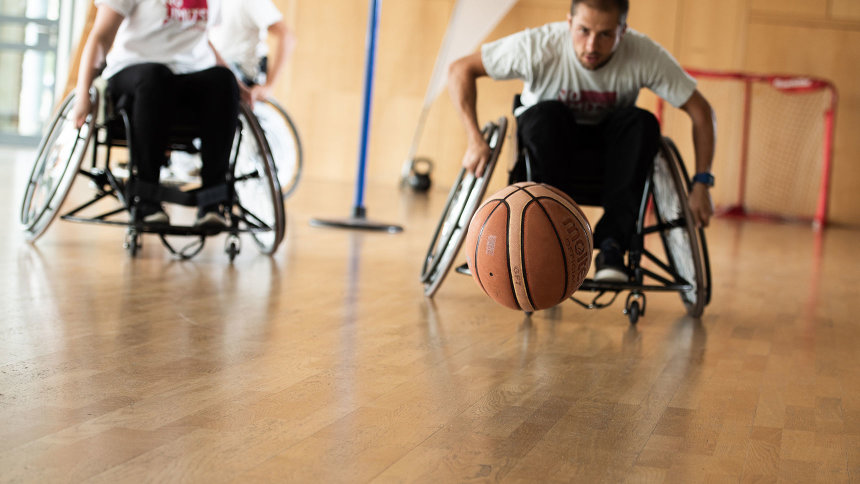 In einer Sporthalle: Zwei Männer beim Rollstuhlbasketball.