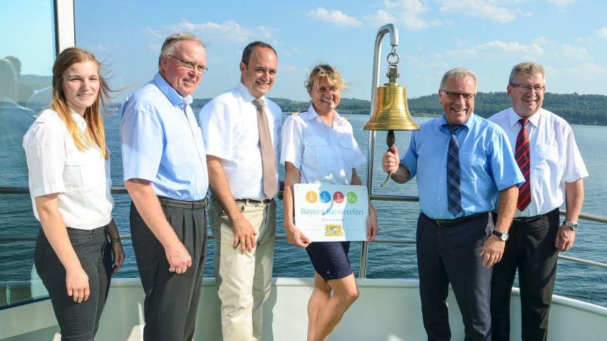 Gruppenbild: Übergabe des Signets „Bayern barrierefrei“ auf einem Ausflugsschiff.