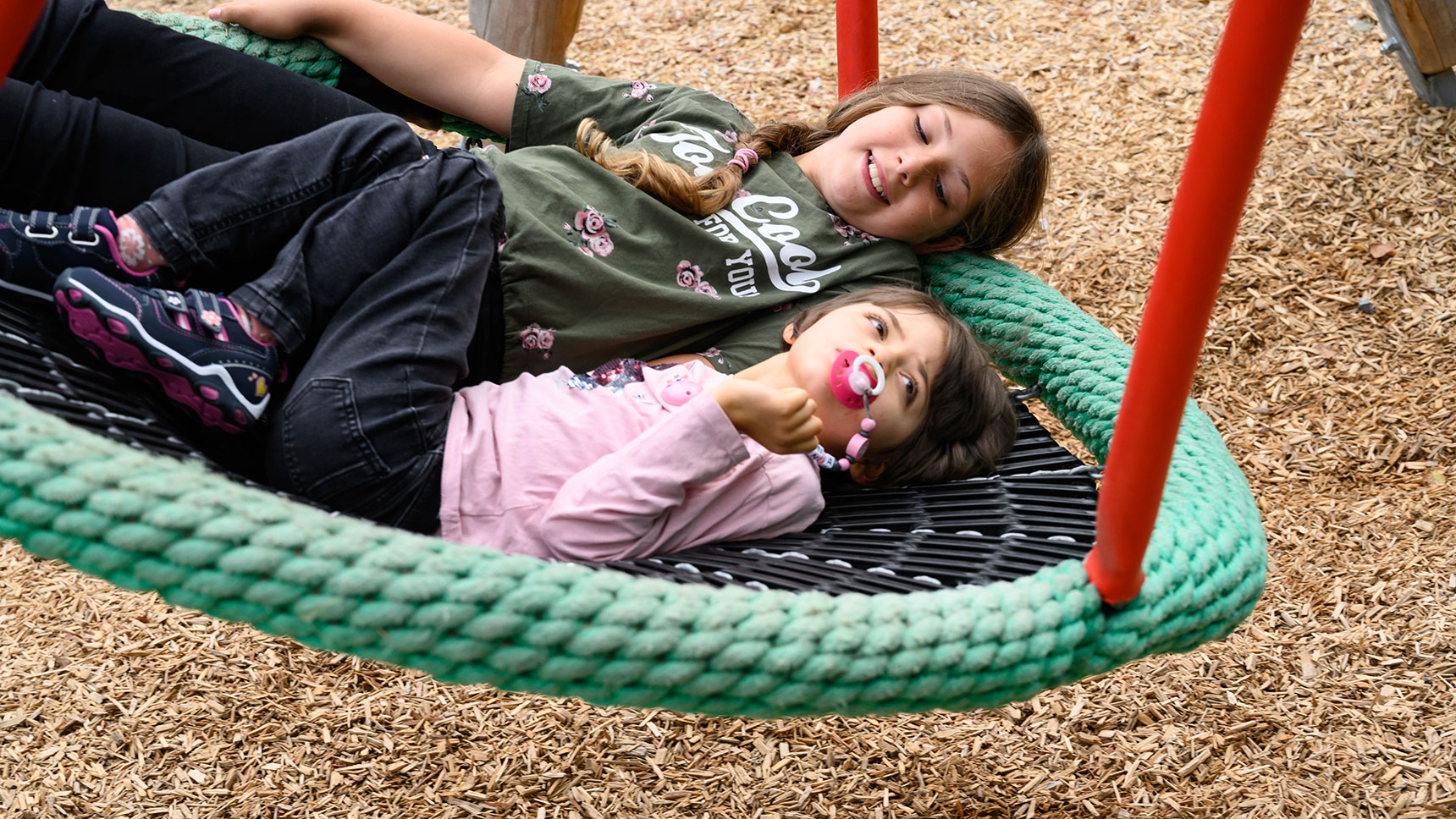 Nahaufnahme: Lea und Hanna in der Nestschaukel.