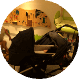Ein Kinderwagen steht vor einer Spielecke mit Wickeltisch.