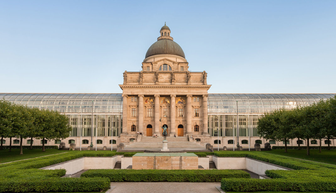 Die Bayerische Staatskanzlei, davor ein Teil des Hofgartens.