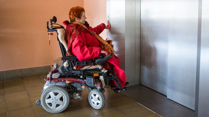 Dinah Radtke mit Rollstuhl vor einem Lift.