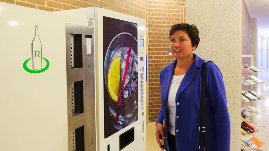 Irmgard Badura geht an einem Getränke-Automaten vorbei.