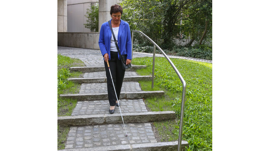 Irmgard Badura auf einer Treppe mit Natursteinpflaster im Außenbereich.