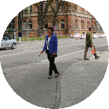 Irmgard Badura tritt vom Gehweg auf eine Fahrradspur. Fuß- und Radweg sind sichtbar, aber nicht taktil erfassbar voneinander abgesetzt.