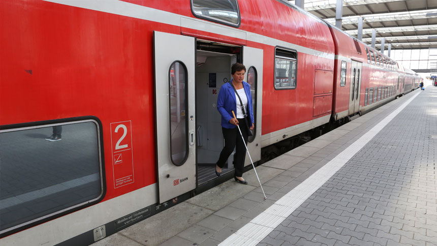 Irmgard Badura hat den Zug verlassen und orientiert sich mit dem Langstock.