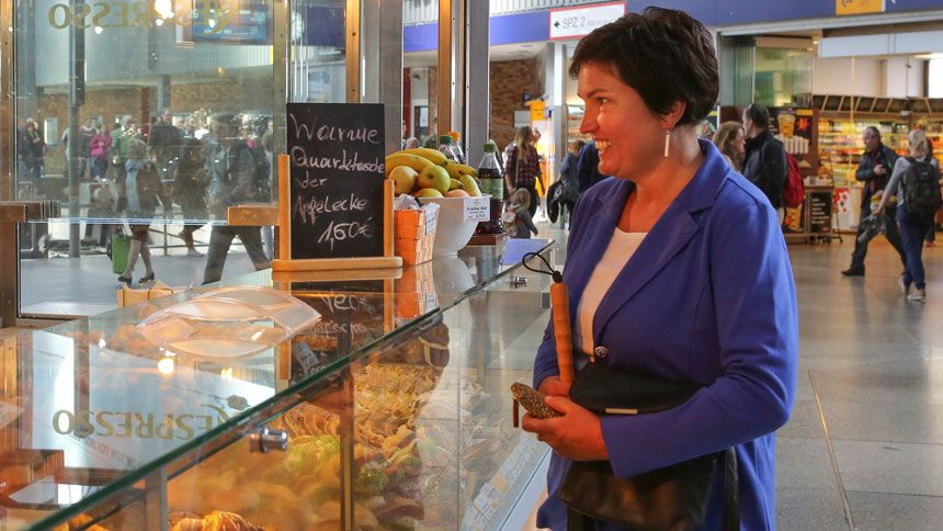 Irmgard Badura an der Theke eines Bäckerei-Verkaufsstandes in der Bahnhofshalle.