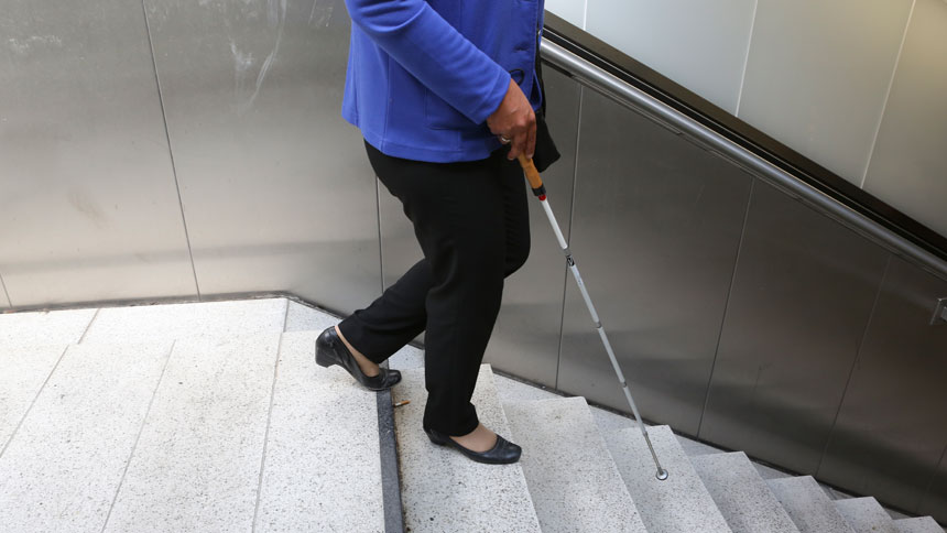 Irmgard Badura auf der ersten Stufe einer Treppe, die ins Bahnhofs-Zwischengeschoss führt.