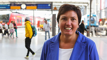 Porträtfoto von Irmgard Badura; im Hintergrund ist die Halle des Münchner Hauptbahnhofs zu sehen.