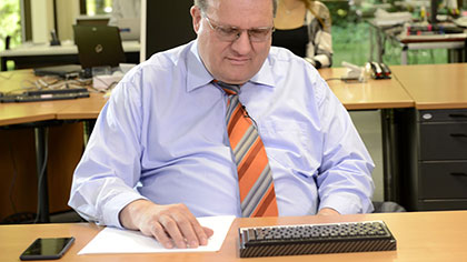 Klaus-Peter Wegge am Schreibtisch; er liest ein Schriftstück.