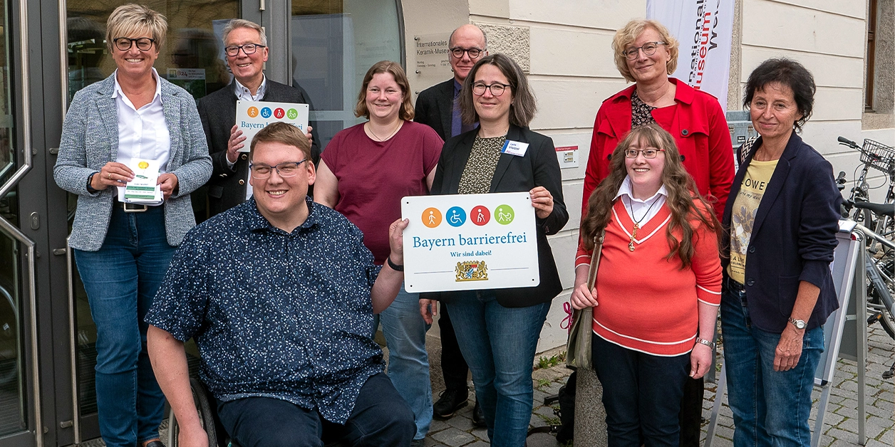 Gruppenbild: Präsentation des Signets „Bayern barrierefrei” vor der Regionalbibliothek Weiden.