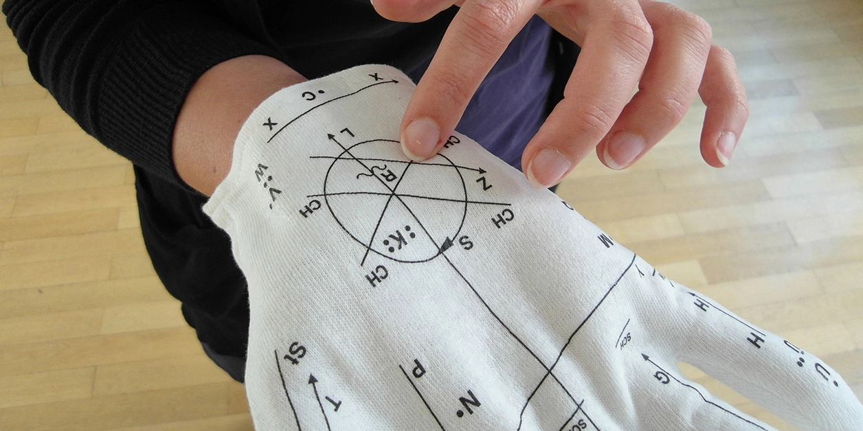 Finger streicht über einen Lorm-Handschuh.
