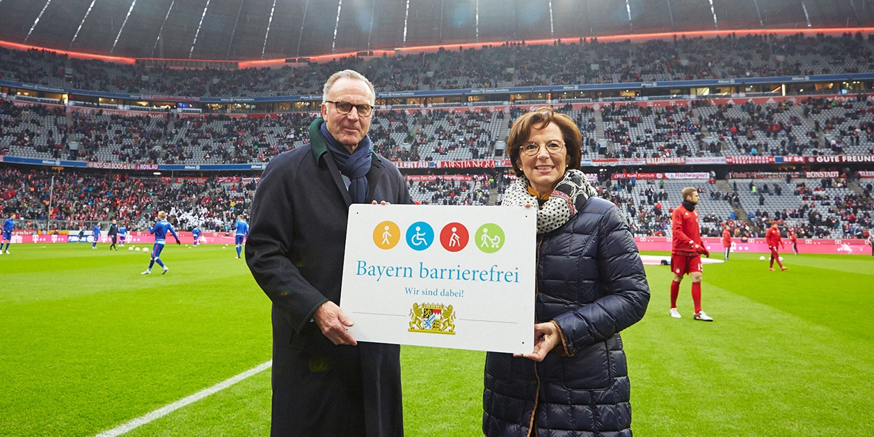 Sozialministerin Emilia Müller und FC-Bayern-Chef Karl-Heinz Rummenigge mit dem Signet „Bayern barrierefrei“.
