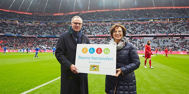 Sozialministerin Emilia Müller und FC-Bayern-Chef Karl-Heinz Rummenigge mit dem Signet „Bayern barrierefrei“.