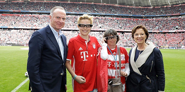 Gruppenfoto: hörbehinderte Fans in der Allianz Arena mit Sozialministerin Emilia Müller und Bayern-Chef Karl-Heinz Rummenigge.