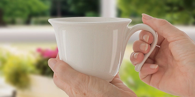 Nahaufnahme: Hände einer alten Dame mit Tasse.