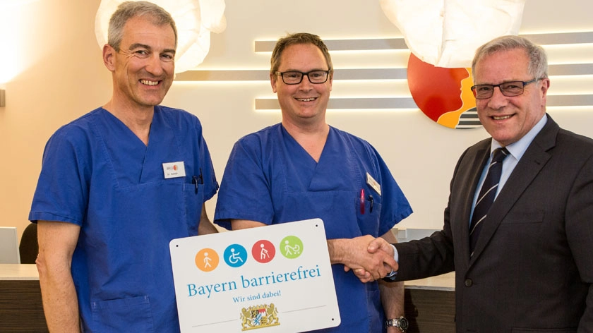 Johannes Hintersberger übergibt das Signet „Bayern barrierefrei“ an Alexander Rudolph und Stefan Hessenberger.