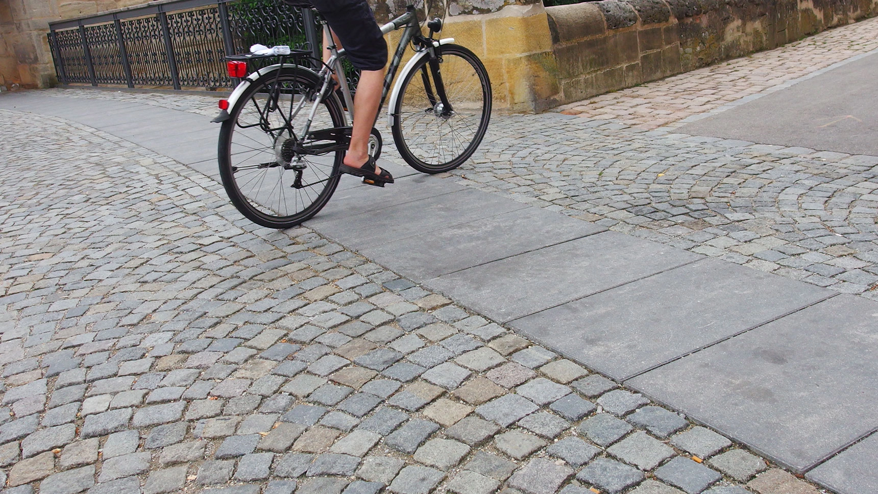 Radfahrer rollt über Segmentpflaster und Laufband.