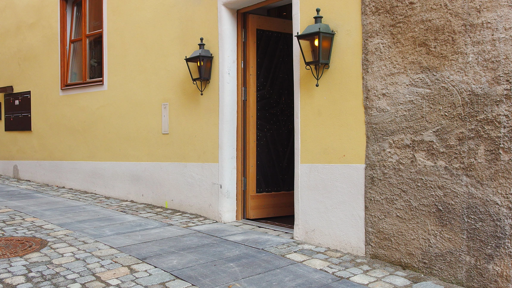 Gepflasterte Altstadtgasse mit barrierefreiem „Laufband“.