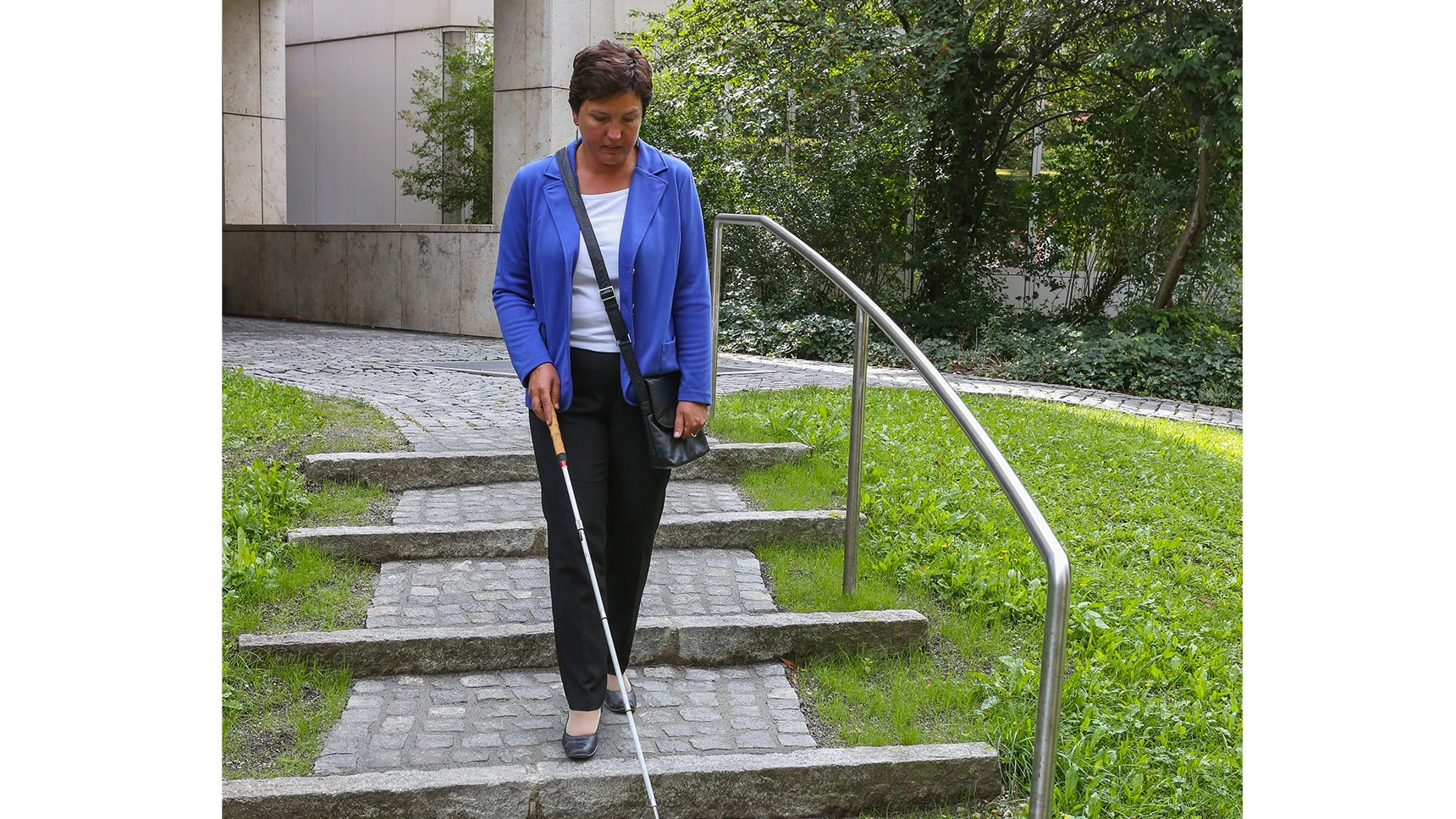 Irmgard Badura auf einer Treppe mit Natursteinpflaster im Außenbereich.