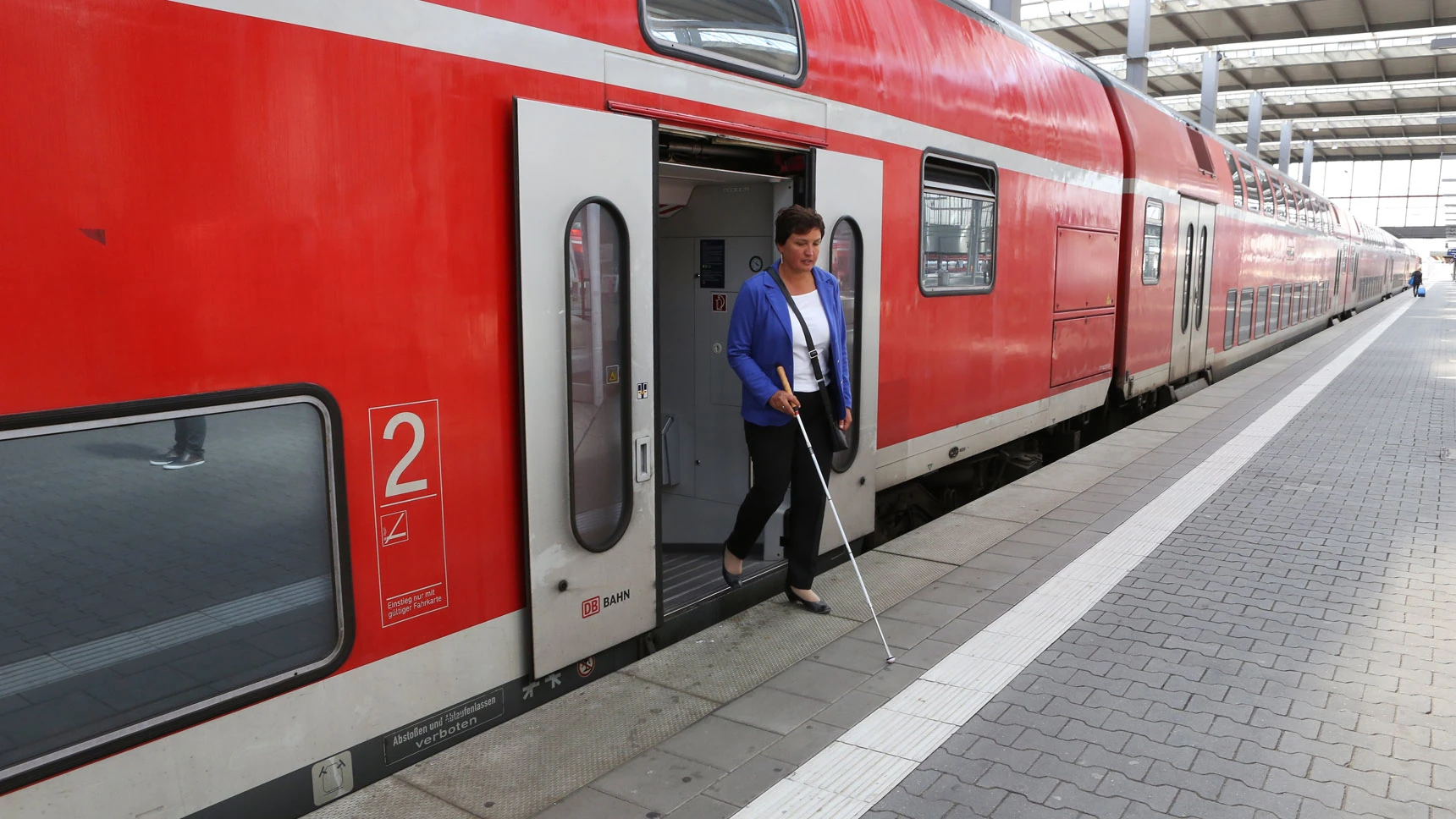 Irmgard Badura hat den Zug verlassen und orientiert sich mit dem Langstock.