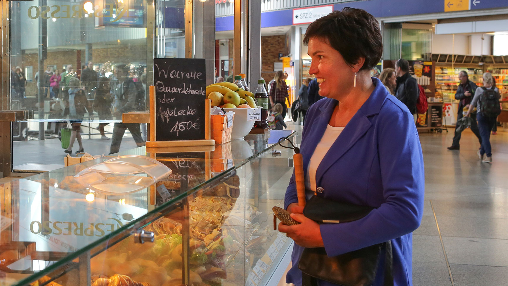 Irmgard Badura an der Theke eines Bäckerei-Verkaufsstandes in der Bahnhofshalle.