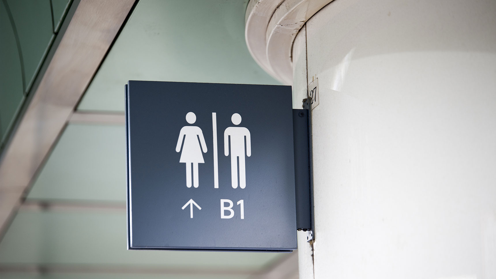 Toiletten-Wegweiser an einer Wand.