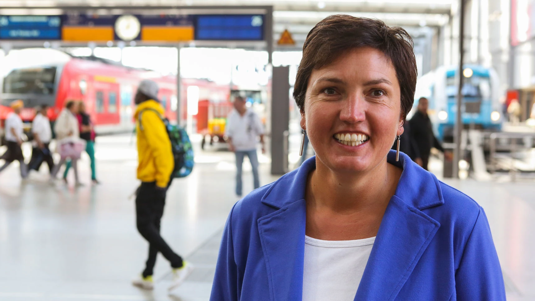 Porträtfoto von Irmgard Badura; im Hintergrund ist die Halle des Münchner Hauptbahnhofs zu sehen.