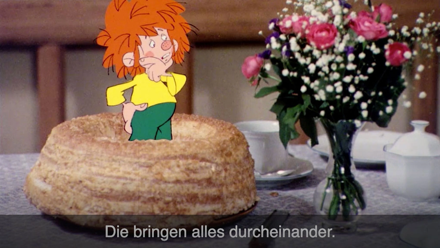 Pumuckl steht in einem Kuchen neben einem Blumenstrauß. Untertitel: Die bringen alles durcheinander.